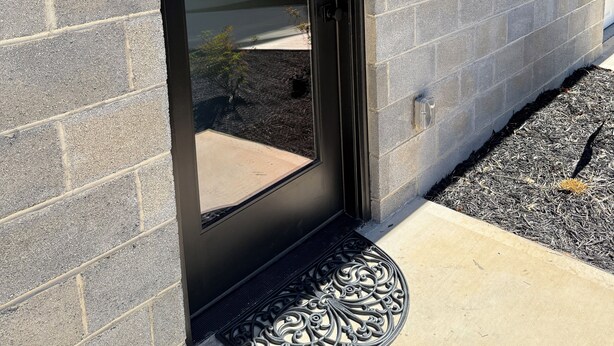 A modern building with a stone facade, a black door, and a mailbox. - 2BR 2.5 Downtown Oasis Full Kitchen, Pet Friendly, Close to Silos Food Hall (Easley)