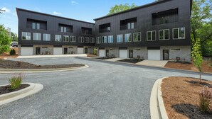 A modern building with a symmetrical facade, multiple windows, and a central entrance. - 2BR 2.5 Downtown Oasis Full Kitchen, Pet Friendly, Close to Silos Food Hall (Easley)