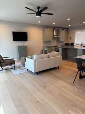 Relax in this inviting space with a sofa set, leather chair, and dining area.