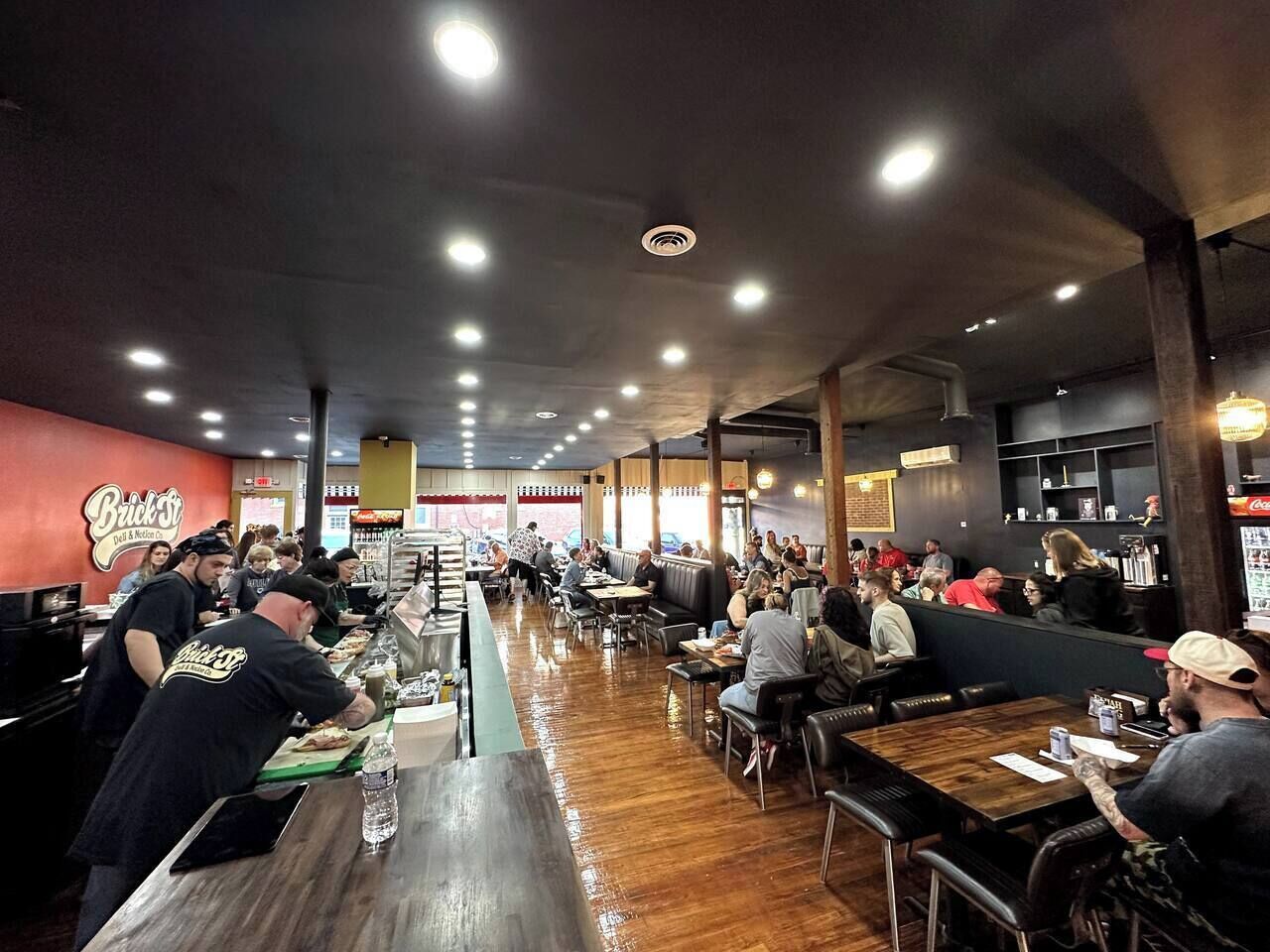 Un restaurante con una barra larga, mesas y cabinas.