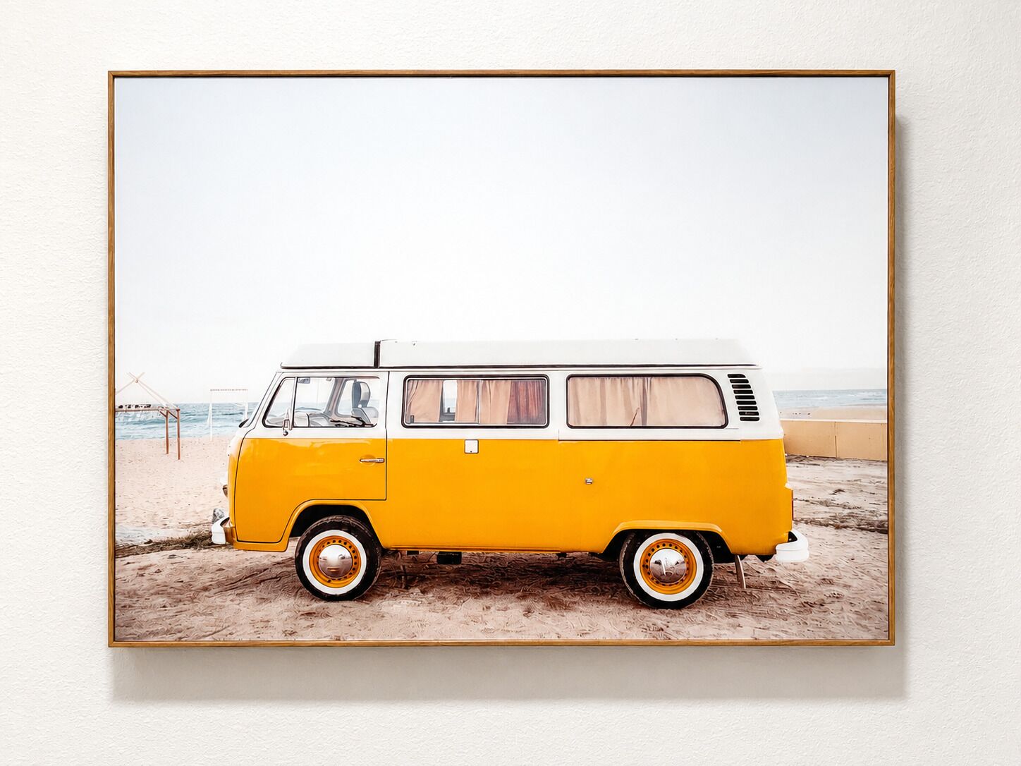 Una camioneta blanca y amarilla estacionada en la playa.