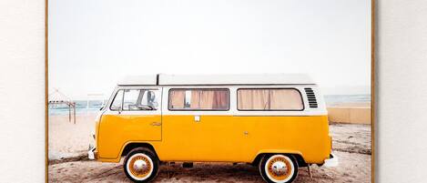 Una camioneta blanca y amarilla estacionada en la playa.