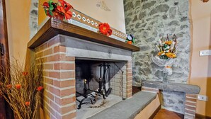 A fireplace with a brick surround, a stone mantle, and a decorative shelf above. - The Granary - Farmhouse La Fattoria (Monte Santa Maria Tiberina)