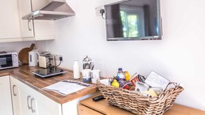 A kitchen with a microwave, toaster, kettle, and a TV mounted on the wall. - The Stables at Ballygraffan, outside. Comber - Harry's Stable (Comber)