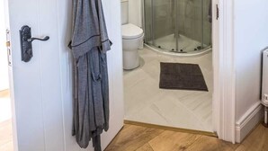 A modern bathroom with a glass-enclosed shower, a white toilet, and a wooden floor. - The Stables at Ballygraffan, outside. Comber - Harry's Stable (Comber)