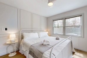 Relax in this serene bedroom with a single bed, bedside table, and large window offering a view of the outside.