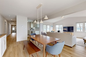 Relax in a spacious living area with a dining table, comfortable seating, and a large window offering a view of the outdoors.