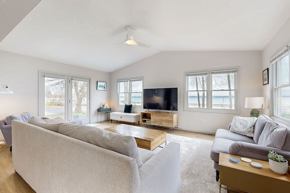 Relax in this stylish living space with a large sofa, flat-screen TV, and comfortable armchair.