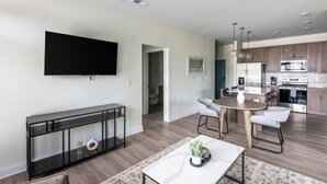 A modern living room with a flat-screen TV, a console table, and a coffee table.