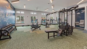 A gym with various exercise equipment, large windows, and a green patterned floor. - Landing Apartments Santa Rosa Beach (Santa Rosa Beach)