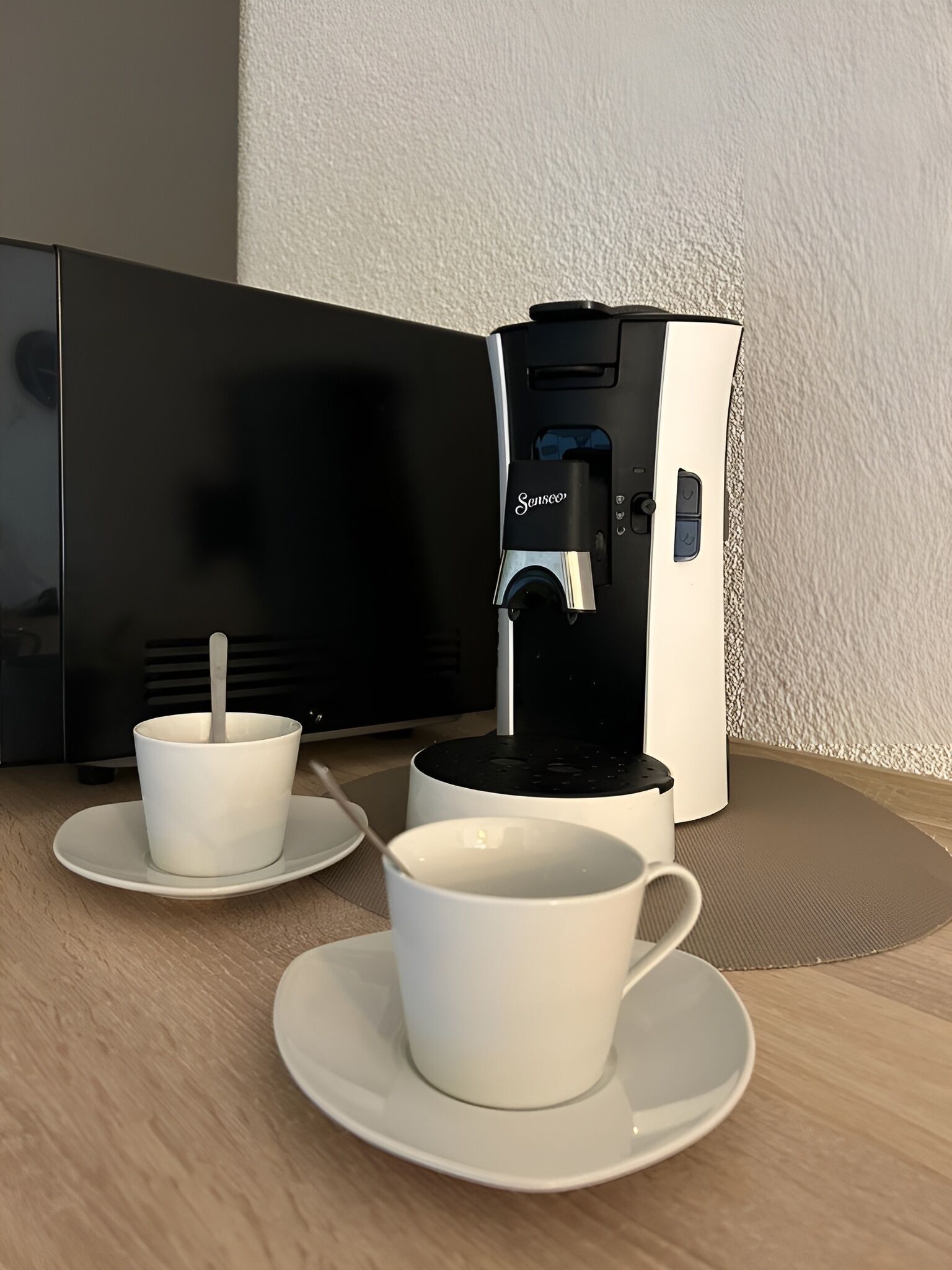 Une machine à café avec deux tasses posées sur une table.