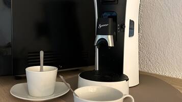 Une machine à café avec deux tasses posées sur une table.