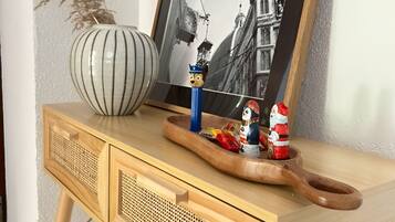 Ein Holztisch mit einem schwarzen und weißen Foto in einem Rahmen, einer gestreiften Vase und kleinen Figuren.