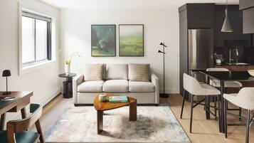 Una sala de estar moderna con sofá, mesa de centro y comedor.