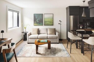 Una sala de estar moderna con sofá, mesa de centro y comedor.