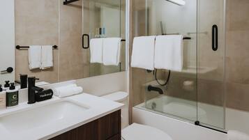 Un baño moderno con ducha acristalada, lavamanos blanco y retrete.
