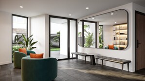 Uma sala de estar moderna com uma janela grande, um banco, duas cadeiras e uma estante embutida.