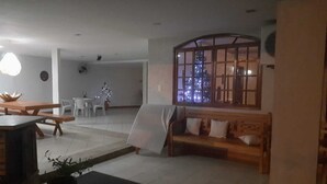 Una sala de estar con un banco de madera, una mesa de comedor y un árbol de Navidad.
