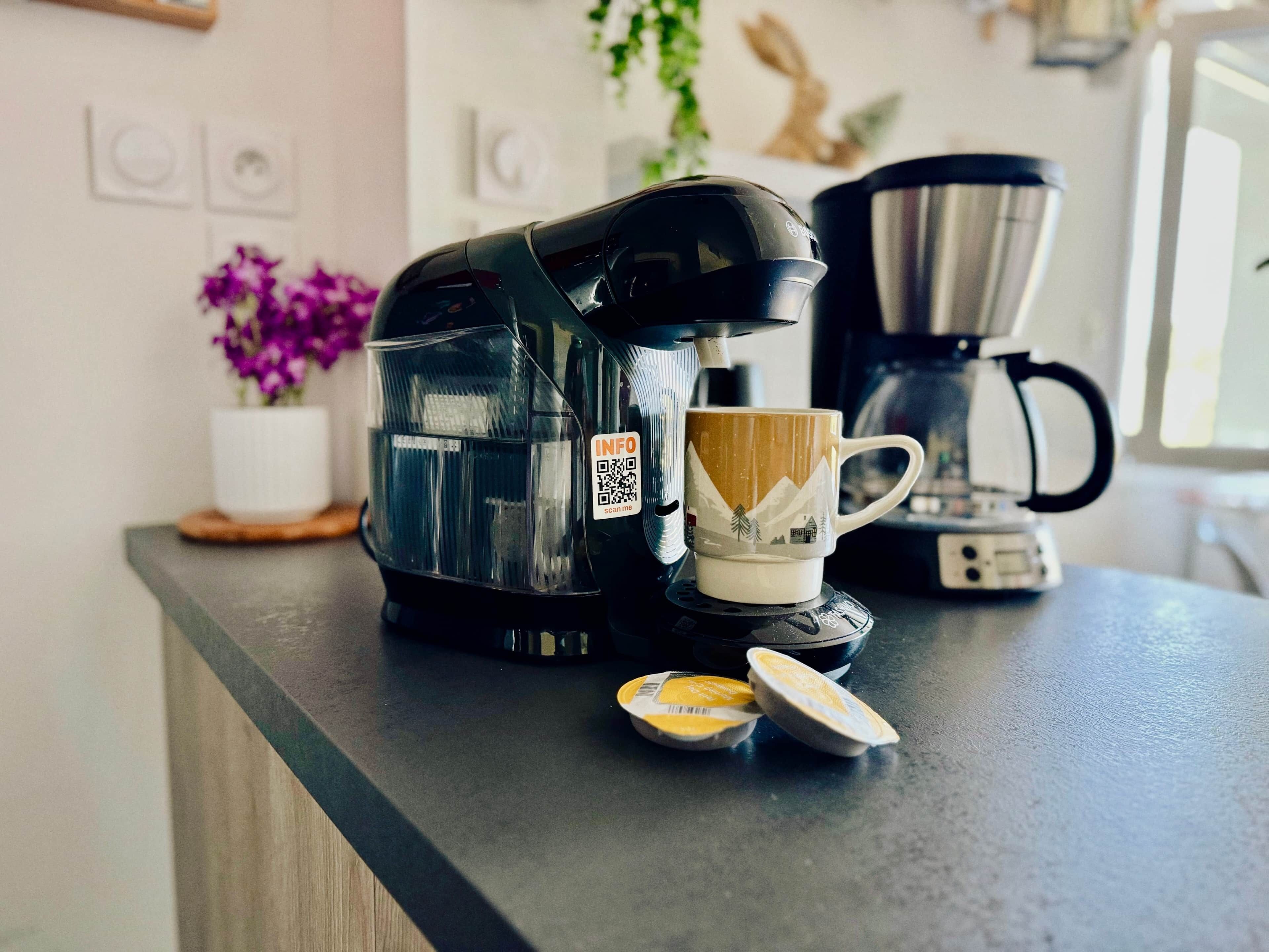 Een aanrecht met een koffiezetapparaat, een mok en een boterbakje.