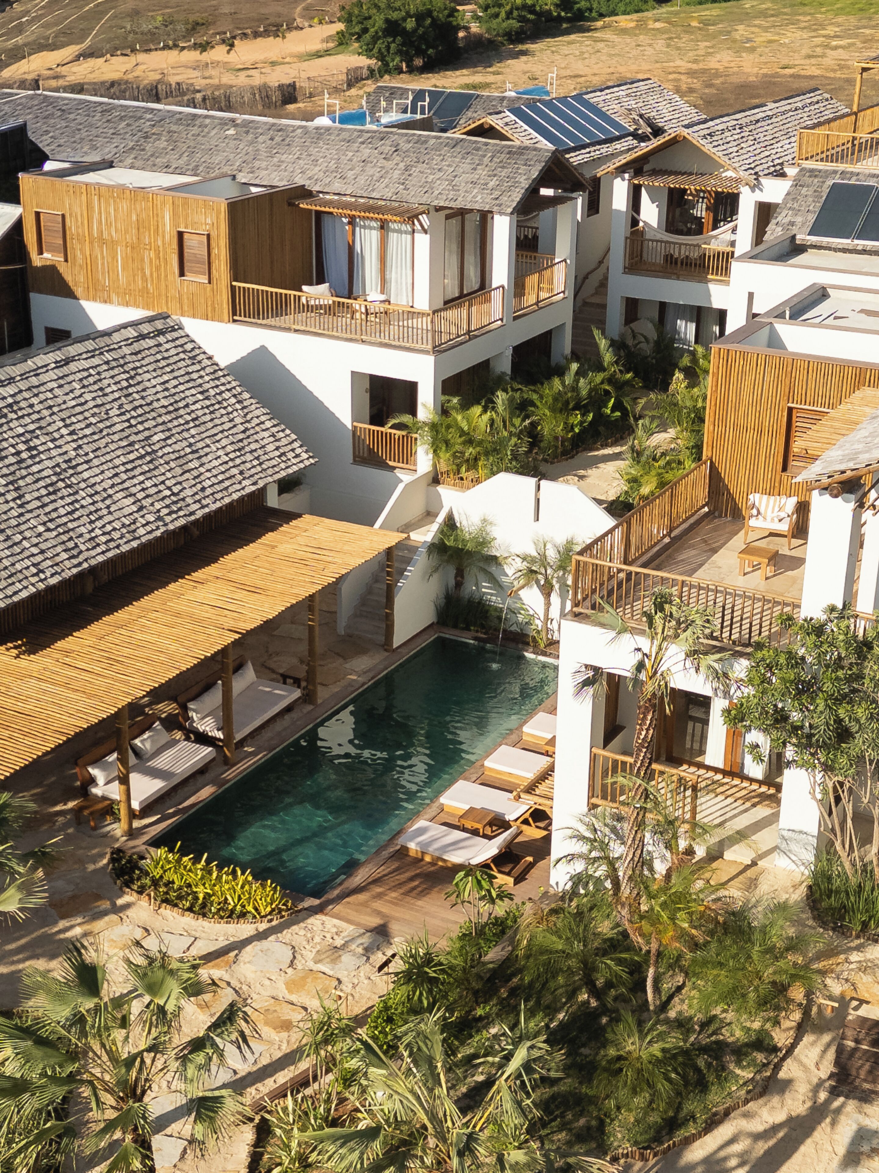 A resort with multiple buildings, a swimming pool, and outdoor seating areas.