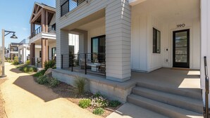 A modern two-story building with a covered porch, a visible door marked "1190", and a staircase leading to the entrance. - Fox Point Farms Retreat with Ocean Views - extended stays (Encinitas)