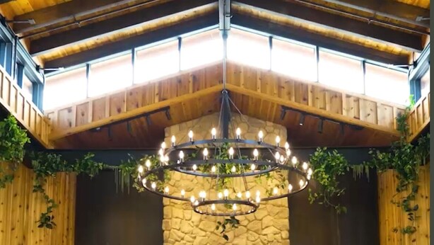 A cozy interior with a stone fireplace, wooden ceiling, and a chandelier. - Fox Point Farms Retreat with Ocean Views - extended stays (Encinitas)