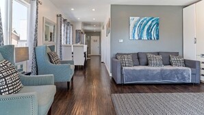 A modern living room with a grey sofa, blue armchairs, and patterned cushions. - Sf City Ocean View. Free parking inside the compound. 15 min beach Drive (Oakland)