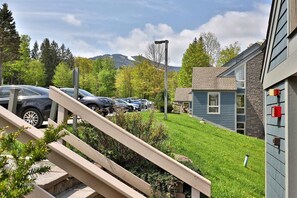 A residential area with a parking lot, a staircase, and a house with a stone facade.