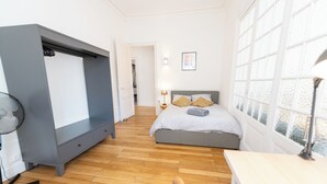 A bedroom with a bed, bedside table, and a desk.
