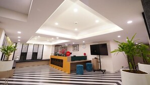 A modern hotel lobby with a reception desk, seating area, and a large flat-screen TV. - Spree Hotel Kriday Dehradun (Dehradun)