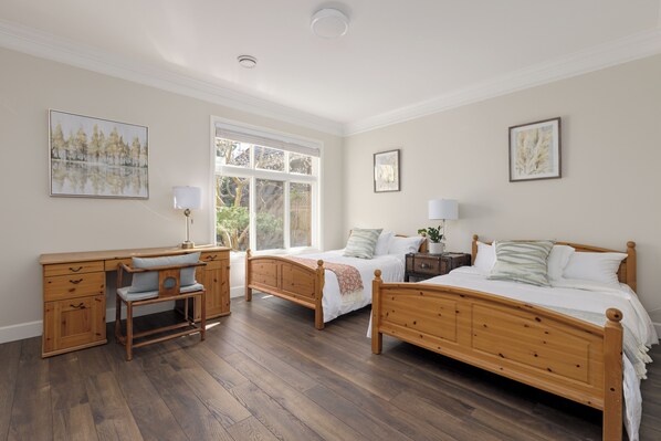 A bedroom with two wooden beds, a desk, and a chair. -  Family Room.  2 Double Beds.  Private Bath. Free Parking .Central AC. (Richmond)