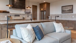 A modern kitchen with a central island, wooden cabinets, and pendant lighting. - Middle Teton 2N | Stunning Views + Private Balcony (Driggs)