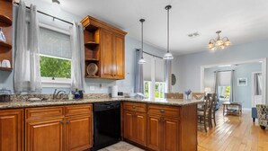 A kitchen with wooden cabinets, a dishwasher, and a granite countertop.
