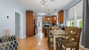 A modern kitchen with wooden cabinets, a central island, and pendant lighting.
