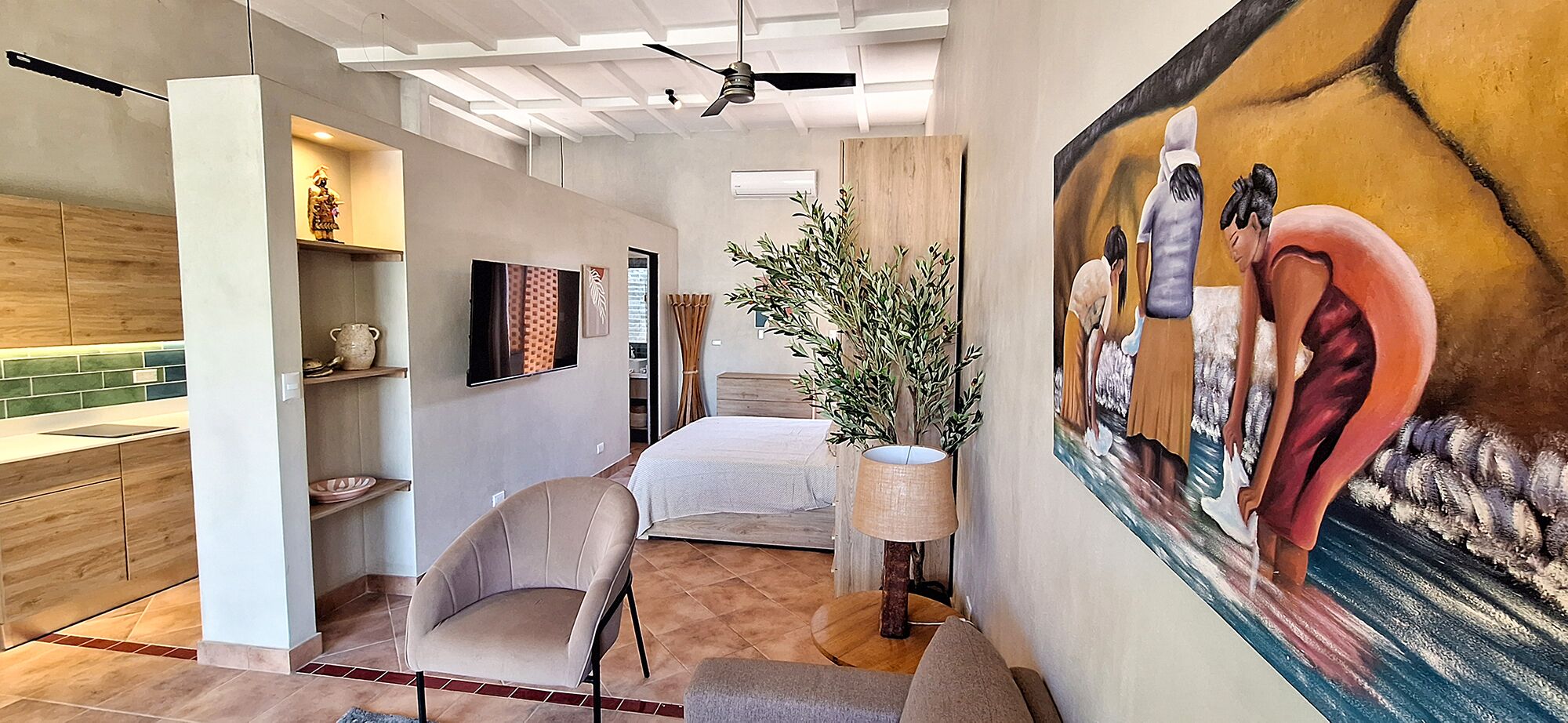A modern bedroom with a bed, a chair, a painting, and a plant.