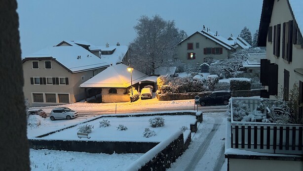 A residential street with houses, a snow-covered road, and a parked car. - Cosy studio with views of Lake Geneva and Mont Blanc (Arzier-Le Muids)