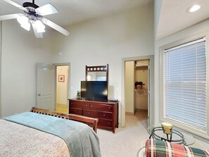 A bedroom with a bed, dresser, mirror, ceiling fan, and a window with blinds. - Beautiful Day by Taylor Made Deep Creek (McHenry)