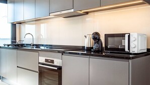 Une cuisine moderne équipée d’appareils électroménagers en acier inoxydable, d’un four encastré et d’un four à micro-ondes.