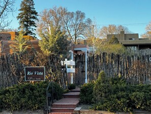 A sign for Rio Vista at 527 East Alameda, with a wooden fence and steps leading to a building.