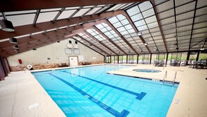 Ein Hallenbad mit deutlichen Fahrspuren, einem überdachten Dach und einer Steinwand im Hintergrund.