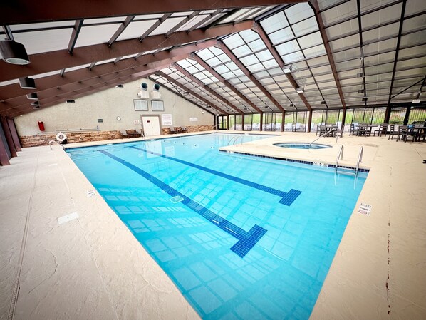 Una piscina interior con marcas de carriles bien definidas, techo cubierto y pared de piedra de fondo.