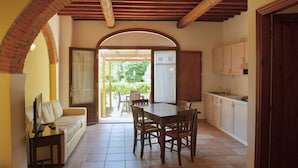 A dining area with a table and chairs, a sofa, a TV, and a kitchen with cabinets and a sink. - Two-room apartment of about 45 square meters with air conditioning and heating, tastefully furnished and composed of a living room with equipped kitchenette and sofa bed, bedroom with double bed and bathroom with shower and bidet.Located on the ground fl (Riparbella)