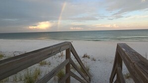 A wooden boardwalk leading to a beach with a visible rainbow in the sky. - DuneFine Cape San Blas Sleeps 10 & Dog Friendly Private Pool (Cape San Blas)