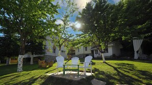 A backyard with a white table and chairs, surrounded by trees and a house. - Abant Luna (Bolu)