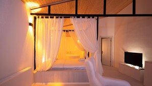 A bedroom with a bed, a chair, a television, and a window with curtains. - Abant Luna (Bolu)