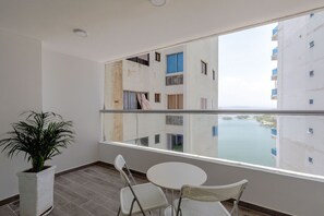 Un balcón con vista a un edificio y un cuerpo de agua.