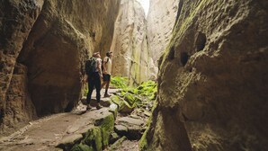 Un sentier étroit dans un canyon, avec des randonneurs.