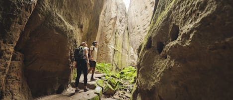 Un estrecho sendero en un cañón con excursionistas.