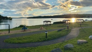 Un parque junto al lago con senderos peatonales, zonas de picnic y un pabellón.