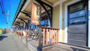 Un bar en esquina con terraza al aire libre, una cubierta de madera y una puerta que indica "Vacation Rental".